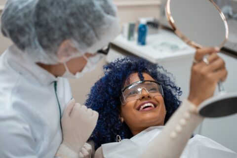 Woman admiring her smile after cosmetic dental procedure in Grand Rapids, MI