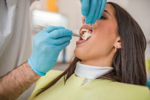 A dental professional performing a tooth extraction on a patient in Grand Rapids, MI
