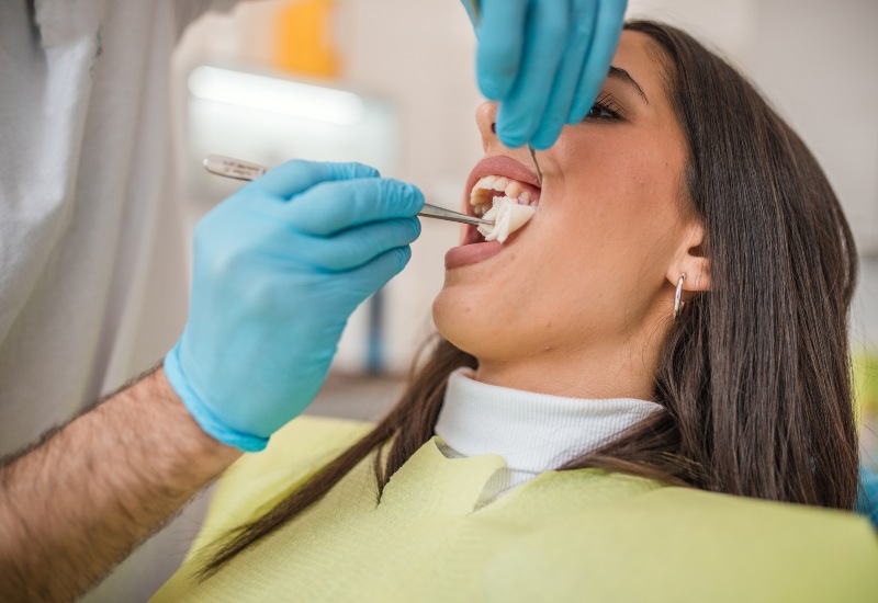 A dental professional performing a tooth extraction on a patient in Grand Rapids, MI